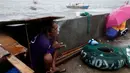 Seorang nelayan saat berlindung di trotoar ditengah cuaca buruk akibat Topan Nepartak yang menerpa di Manila Bay, Filipina, Jumat (8/7). (REUTERS/Erik De Castro)