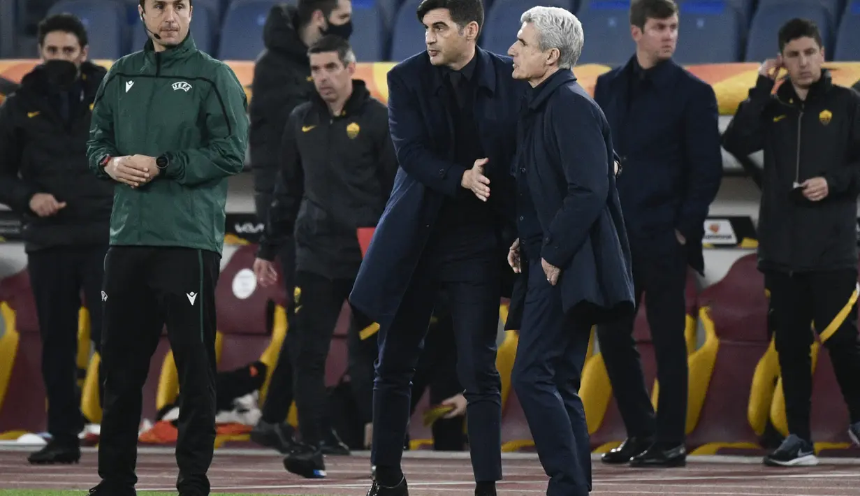 Pelatih AS Roma, Paulo Fonseca (tengah) menyapa pelatih Shakhtar Donetsk, Luis Castro (kanan) usai pertandingan leg pertama babak 16 besar Liga Europa di stadion Olimpiade, Italia, Jumat (12/3/2021). AS Roma menang telak atas Shakhtar Donetsk 3-0. (AFP/Filippo Monteforte)