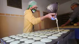 Warga membuat penganan manis tradisional yang dikenal dengan nama Qatayef di Kota Rafah, Jalur Gaza, Palestina, Senin (27/4/2020). Qatayef adalah sejenis makanan penutup khas Arab yang biasa dibuat saat bulan suci Ramadan. (Xinhua/Khaled Omar)