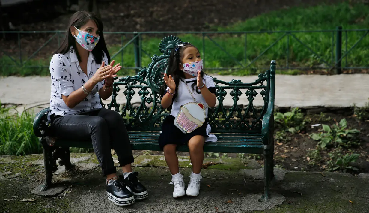 Penduduk bertepuk tangan ketika Percibald Garcia membaca buku untuk anak-anak dengan pengeras suara di kompleks perumahan Tlatelolco di Mexico City pada 18 Juli 2020. Lockdown akibat pandemi corona membuat arsitek muda itu memutuskan untuk berbagi cerita menghibur anak-anak. (AP/Marco Ugarte)