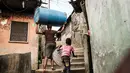 Seorang wanita membawa drum plastik di permukiman informal Urualla di Port Harcourt, Nigeria selatan (14/2). Nigeria akan mengadakan pemilihan presiden dan parlemen 16 Februari 2019. (AFP Photo/Yasuyoshi Chiba)