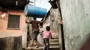 Seorang wanita membawa drum plastik di permukiman informal Urualla di Port Harcourt, Nigeria selatan (14/2). Nigeria akan mengadakan pemilihan presiden dan parlemen 16 Februari 2019. (AFP Photo/Yasuyoshi Chiba)