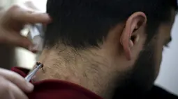 Pria Palestina, yang menderita masalah saraf di leher dan punggung, menerima terapi sengatan lebah di klinik Rateb Samour, Kota Gaza, 11 April 2016. Samour mengobati 250 pasien sehari, dengan keluhan dari rambut rontok hingga kanker (REUTERS/Suhaib Salem)