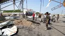 Seorang tentara dan warga sipil melihat lubang besar akibat serangan udara Saudi di pintu masuk kota pelabuhan Laut Merah di Hodeidah, Yaman, Minggu (4/9). (REUTERS/Abduljabbar Zeyad)