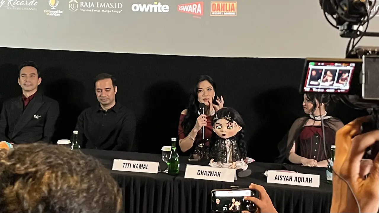 Titi Kamal, memegang mic dalam konferensi pers dan screening film "The Doll Ghawiah" di kawasan Jakarta pada (16/10/2026)/ (Liputan6.com/Afradhiya N. R)