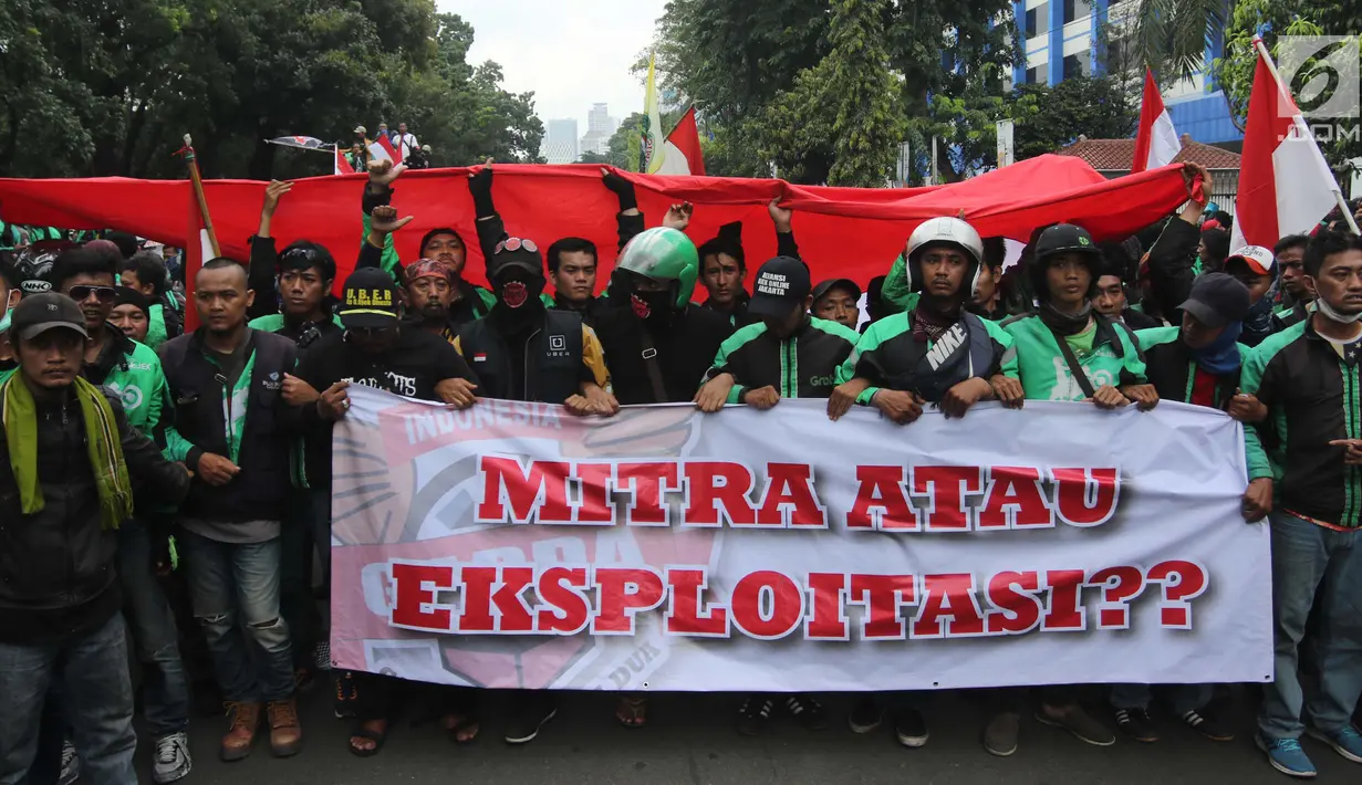 Sejumlah pengemudi ojek online membentangkan spanduk saat menggelar aksi di seberang Istana Merdeka, Jakarta, Selasa (27/3). Dalam aksinya mereka menuntut pemerintah melakukan penetapan tarif standar dengan nilai yang wajar. (Liputan6.com/Arya Manggala)
