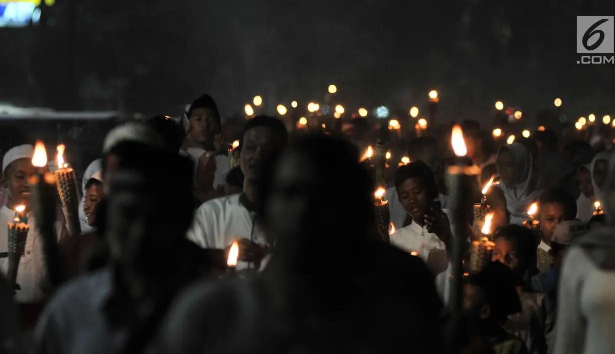 Warga membawa obor saat pawai Tahun Baru Islam 1440 H di kawasan Menteng, Jakarta, Senin (10/9). Pawai obor yang diiringi musik bernuansa Islam merupakan tradisi umat muslim di Indonesia menyambut Tahun Baru 1 Muharram. (Merdeka.com/Iqbal S Nugroho)