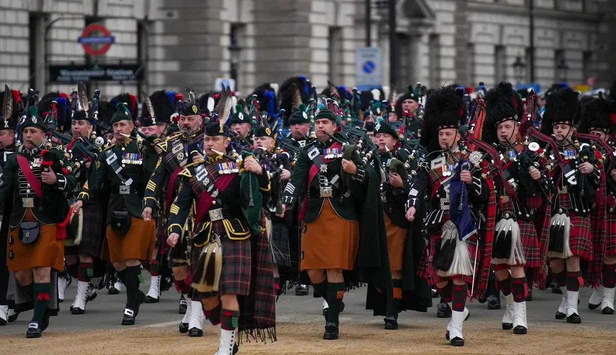 Marching band tampil jelang upacara pemakaman Ratu Elizabeth II di pusat kota London, Inggris, Senin (19/9/2022). Selain polisi London, akan ada bala bantuan dari 43 pasukan polisi Inggris pada prosesi pemakaman Ratu Elizabeth II. (AP Photo/Emilio Morenatti,Pool)