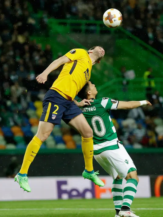 Pemain Atletico Madrid, Diego Godinberebut bola dengan pemain Sporting CP, Fredy Montero pada leg kedua perempat final Liga Europa di Estadio Jose Avalade, Jumat (13/4). Atletico Madrid tetap maju ke semifinal meski kalah 0-1.  (AP/Armando Franca)