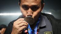 Pelatih Timnas Indonesia U-16, Bima Sakti, mencium medali juara setelah membawa timnya menjuarai Piala AFF U-16 2022 di Stadion Maguwoharjo, Sleman, Jumat (12/8/2022). (Bola.com/Bagaskara Lazuardi)