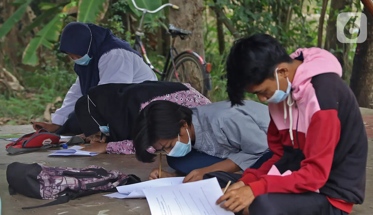 Para murid SMP Sekolah Alam mengisi soal Ujian Akhir Semester (UAS) di Sukawangi, Kabuapaten Bekasi, Jawa Barat, Senin (30/11/2020). Menurut pengurus Sekolah Alam KBM tatap muka  jenjang pendidikan SD,SMP, dan SMA tetap berjalan dengan menerapkan protokol kesehatan. (Liputan6.com/Herman Zakharia)