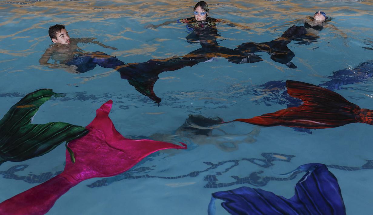 Siswa melakukan rutinitas selama kelas putri duyung mereka di Merschool di Kayalami, dekat Midrand, Afrika Selatan pada 3 Juni 2022. - Mermaiding adalah olahraga yang berkembang pesat di seluruh dunia dan mencakup beberapa keterampilan seperti berenang monofin, mengayuh, trik, dan menahan napas. (Phill Magakoe / AFP)