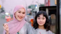 Ayu Ting-ting tampil kembar dengan sang putri kenakan kaftan abu-abu bermotif bunga. Dipadukan dengan kerudung pink dan sling bag hijau yang bikin Ayu Ting-Ting tampil menawan. [@ayutingting92]