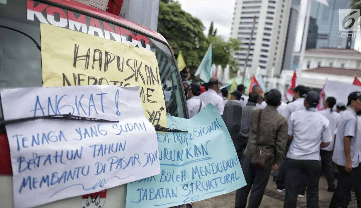 Sejumlah poster dalam unjuk rasa yang digelar oleh massa dari Serikat Pegawai PD Pasar Jaya di depan Balai Kota DKI Jakarta, Rabu (31/1). Mereka menolak tenaga profesional PKWT & PKWTT yang Kolusi, korupsi, Nepotisme (KKN).  (Liputan6.com/Faizal Fanani)