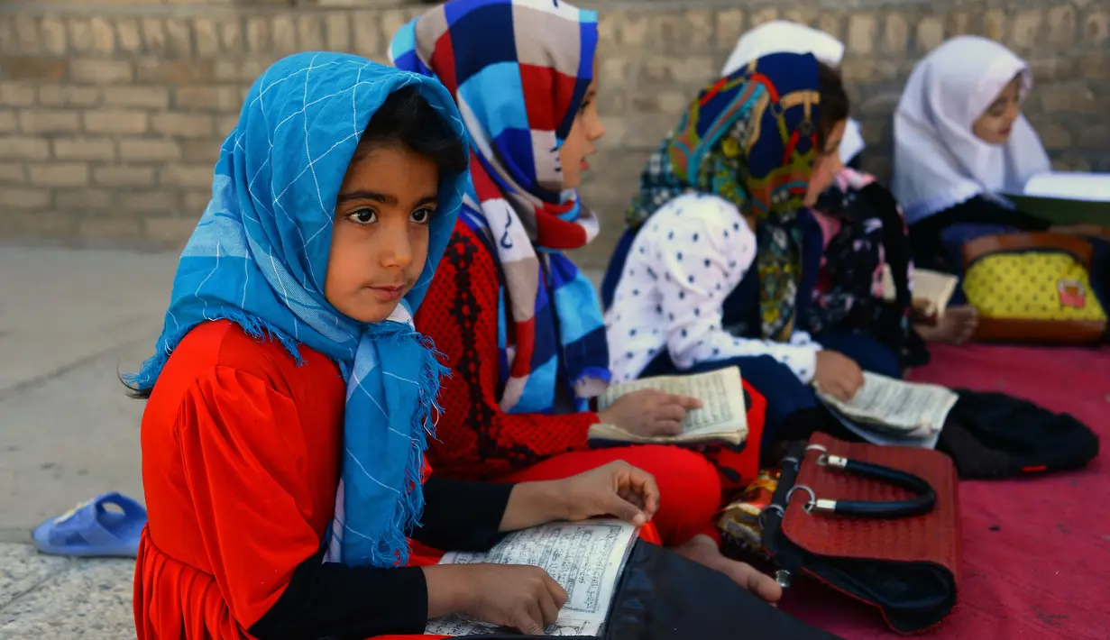 Anak-anak wanita mempelajari Alquran selama bulan suci Ramadan di masjid di Herat, Afghanistan, Sabtu (19/5). Anak-anak Afghanistan lebih memperdalam Alquran di saat Ramadan. (HOSHANG HASHIMI/AFP)