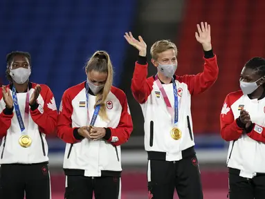 Pesepak bola Kanada Quinn (kedua kanan) melambai saat seremoni penyerahan medali setelah mengalahkan Swedia dalam pertandingan sepak bola putri Olimpiade Tokyo 2020, di Yokohama, Jepang pada 7 Agustus 2021. Quinn menjadi atlet transgender pertama yang memenangkan medali Olimpiade. (AP/Andre Penner)