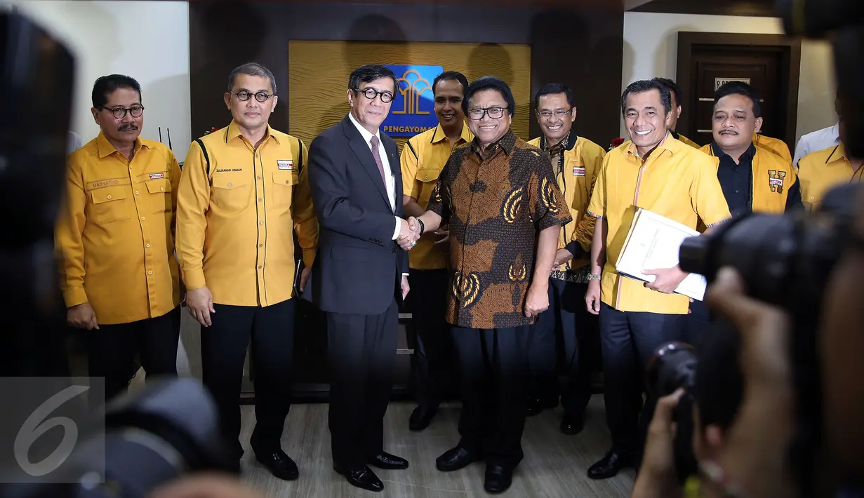 Menkumham Yasonna Laoly (kedua kiri) bersalaman dengan Ketua Umum Partai Hanura Oesman Sapta Odang (OSO) usai memberikan keterangan pers terkait pengesahan struktur organisasi Hanura di kantor Kemenkumham, Jakarta, Rabu (2/1). (Liputan6.com/Johan Tallo)