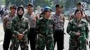 Aparat TNI wanita berjaga saat Hari Buruh Sedunia di depan Istana Negara, Jakarta, Selasa (1/5). Para buruh berbondong-bondong datang menuju Istana Kepresidenan membawa bendera dan atribut masing-masing serikat kerjanya. (Liputan6.com/Johan Tallo)