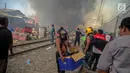 Seorang warga menyelamatkan barangnya saat kebakaran ratusan rumah bedeng di permukiman liar belakang Hotel Alexis, Pademangan, Jakarta, Sabtu (16/9). Untuk memadamkan api, sebanyak 20 unit pemadam kebakaran dikerahkan. (Liputan6.com/Faizal Fanani)