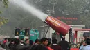 Warga menyaksikan uji coba anti-smog gun atau senjata anti-asap oleh Departemen Lingkungan Hidup dan Komite Pengendalian Pencemaran di New Delhi, Rabu (20/12). India meluncurkan anti-smog gun untuk mengurangi tingkat polusi udara. (SAJJAD HUSSAIN/AFP)