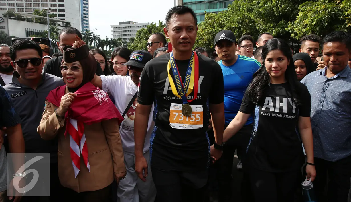 Pasangan Cagub dan Cawagub DKI Jakarta, Agus Harimurti Yudhoyono ditemani Istri Anisa Pohan dan Sylviana Murni menyapa warga Jakarta saat berlangsungnya Car Free Day (CFD) di kawasan Bundaran HI, Minggu (2/10). (Liputan6.com/Johan Tallo)
