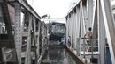 Petugas mengevakuasi bus transjakarta yang terperosok ke sungai usai ditabrak kereta Senja Utama Solo di perlintasan Jalan Mangga Dua, Jakarta, Kamis (19/5). Tak ada korban jiwa, namun sopir Transjakarta mengalami luka berat. (Liputan6.com/Faizal Fanani)