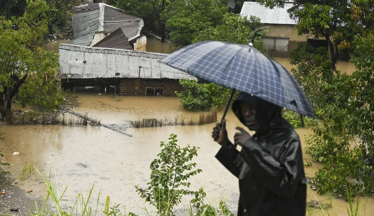 Seorang pria melewati rumah-rumah yang terendam banjir di Blantyre, Malawi Selasa, 14 Maret 2023. Topan Freddy yang tak henti-hentinya melanda Afrika bagian selatan telah menewaskan lebih dari 50 orang di Malawi dan Mozambik sejak melanda benua itu untuk kedua kalinya. pada Sabtu malam, (AP Photo/Thoko Chikondi)