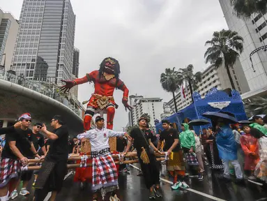Warga mengarak ogoh-ogoh saat pawai budaya di kawasan Bundaran Hotel Indonesia, Jakarta, Minggu (8/3/2026). Pemerintah Provinsi DKI Jakarta menggelar Festival Pawai Ogoh-ogoh 2026 di kawasan Bundaran Hotel Indonesia, Jakarta Pusat. (merdeka.com/Arie Basuki)