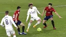 Gelandang Real Madrid, Luka Modric, berusaha melewati pemain Osasuna pada laga Liga Spanyol di Stadion El Sadar, Sabtu (9/1/2021). Kedua tim bermain imbang 0-0. (AP/Alvaro Barrientos)