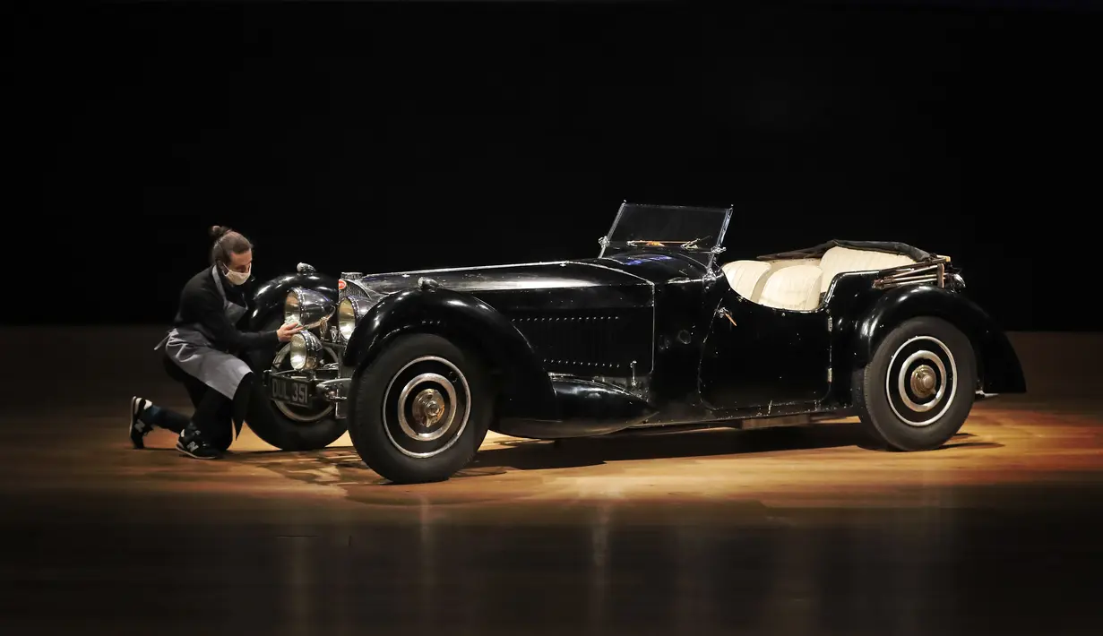 Sebuah Bugatti Type 57S 1937, salah satu mobil pra-perang paling berharga, dipoles oleh staf di rumah lelang Bonhams di London, Selasa (16/2/2021). Seri yang termasuk diburu kolektor mobil langka ini diperkirakan akan terjual 6,95 juta sampai 9,73 juta dollar AS. (AP Photo/Frank Augstein)