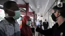 Petugas memeriksa suhu tubuh salah satu warga sebelum memasuki pasar swalayan di Jakarta, Senin (30/3/2020). (merdeka.com/Iqbal S. Nugroho)