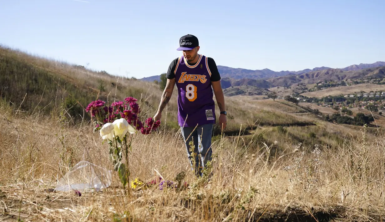 Anthony Calderon mengenakan jersey Kobe Bryant di lokasi kecelakaan helikopter yang menewaskan Bryant, putrinya Gianna, dan tujuh orang lainnya satu tahun lalu di Calabasas, California, Amerika Serikat, Selasa (26/1/2021). (AP Photo/Marcio Jose Sanchez)