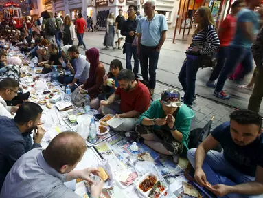 Sejumlah orang mempersiapkan diri untuk berbuka puasa pada hari pertama bulan suci Ramadan, di dekat Taksim Square, Istanbul, Turki, Kamis (18/6/2015). (REUTERS/Osman Orsal)