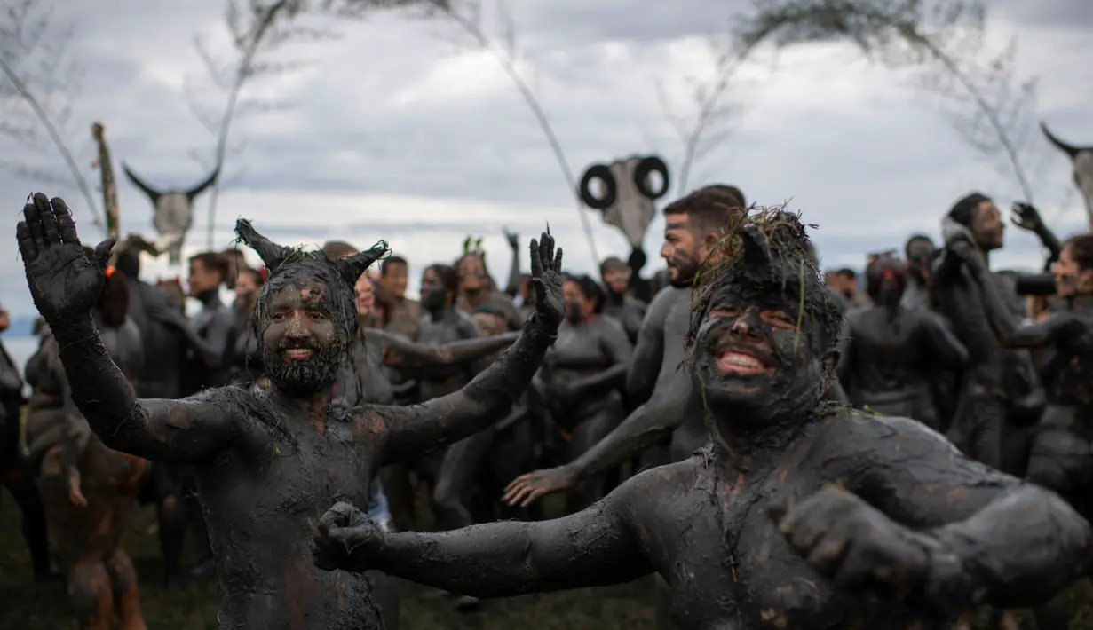 Sejumlah peserta saat mengambil bagian dalam "Bloco da Lama", pesta mandi lumpur di Paraty, negara bagian Rio de Janeiro, Brasil (2/3). Bermain lumpur di tempat ini merupakan acara tradisional di kota bersejarah, Paraty. (AFP Photo/Mauro Pimentel)