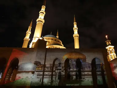 Masjid Al-Amin dan Katedral Christian Maronite saat diterangi cahaya bergambar masjid al-Aqsa dan gereja Makam Suci di Kota Tua Yerusalem di Beirut, Lebanon, (7/12). (AFP Photo/Anwar Amro)