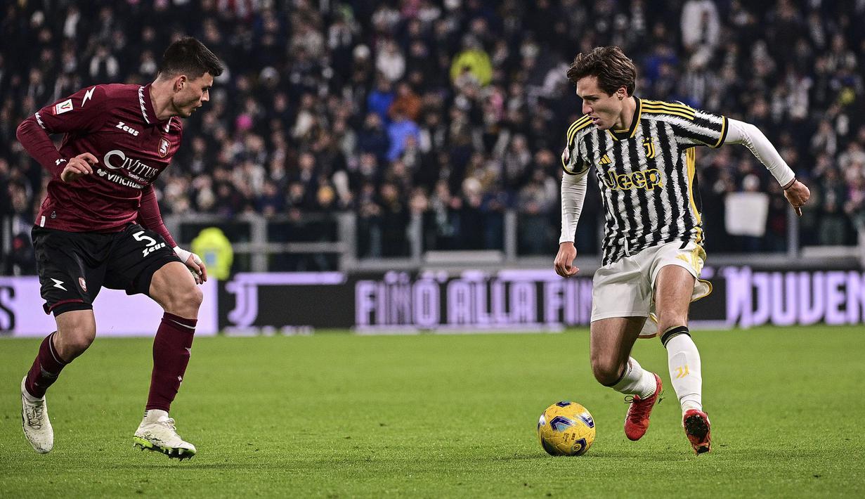 Striker Juventus, Federico Chiesa (kanan) menguasai bola di depan bek Salernitana, Flavius Daniliuc pada laga babak 16 besar Coppa Italia 2023/2024 di Juventus Stadium, Turin, Jumat (5/1/2024) dini hari WIB. (dpa via AP Photo/Marco Alpozzi)
