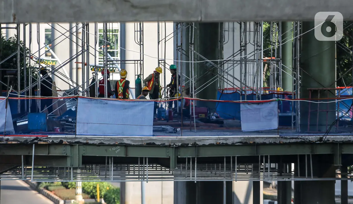 Aktivitas pekerja di area proyek pembangunan skybridge di simpang CSW, Jakarta Selatan, Senin (27/7/2020). Proyek yang akan mengintegrasikan Halte Transjakarta Koridor 1 (Blok M-Kota) dan Koridor (Ciledug-Mampang) dengan Stasiun MRT Asean ditargetkan rampung akhir 2020. (Liputan6.com/Faizal Fanani)