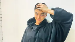 Penggemar akhirnya dapat melihat potongan rambut cepak Song Kang untuk pertama kalinya. Dengan tersenyum malu dia memegang kepalanya. (Foto: Instagram/ songkang_b)