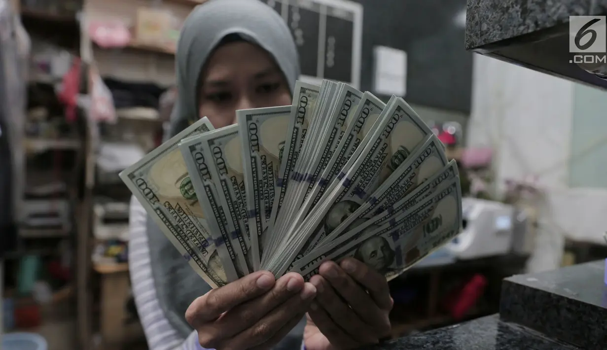 Petugas menunjukkan pecahan uang dolar Amerika di salah satu gerai penukaran mata uang asing di Jakarta, Rabu (5/9). Nilai tukar Rupiah di pasar spot menguat tipis 0,06 persen ke Rp 14.926 per dollar Amerika. (Merdeka.com/Imam Buhori)
