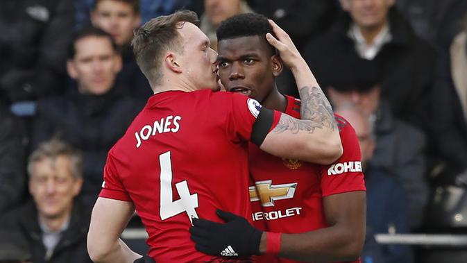 Pemain Manchester United, Phil Jones, merayakan gol yang dicetak Paul Pogba ke gawang Fulham pada laga Premier League di Stadion Craven Cottage, London, Sabtu (9/2). Fulham kalah 0-3 dari MU. (AFP/Ian Kington)