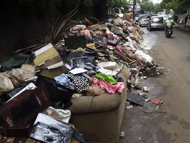 Tumpukan sampah terlihat menumpuk di sepanjang jalan pascabanjir mulai surut di kawasan Kembangan, Jakarta Barat, Minggu (5/1/2020). Pasca banjir yang melanda hampir di kawasan Jakarta mulai surut, tumpukan sampah terlihat di sepanjang jalan dari rumah-rumah warga. (Liputan6.com/Johan Tallo)