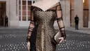 Ariel Tatum dibalut sebuah dress off-the-shoulder bernuansa kehitaman dari kain tenun yang memiliki sentuhan warna emas yang mewah. [Foto: Instagram/arieltatum]