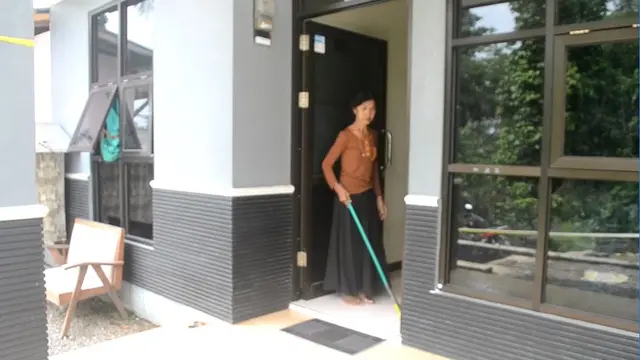 Seperti tak terjadi apa-apa, Sartini, sang asisten rumah tangga keluarga Sidik, berberes rumah. (Foto: Liputan6.com/Muhamad Ridlo)