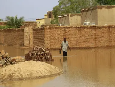 Seorang pria menyusuri jalanan yang tergenang banjir di Khartoum, Sudan (3/8/2020). Sudan dilanda banjir baru-baru ini akibat hujan lebat. (Xinhua/Mohamed Khidir)