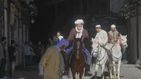 Jemaah haji, termasuk tiga orang dari Spanyol, berpose dengan kuda mereka di luar Pasar al-Hamidiyah&nbsp;di Damaskus, Suriah, 21 April 2025, selama perjalanan berkuda selama berbulan-bulan dari Spanyol ke Arab Saudi untuk melaksanakan ibadah haji. (Dok. AP/Omar Albam)