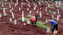 Pekerja sedang melakukan perawatan lokasi pemakaman jenazah yang diduga terinfeksi Covid-19 di TPU Pondok Ranggon, Jakarta, Kamis {30/4/2020). Sejumlah makam terlihat mulai dipasangi rumput dan batu nisan. (Liputan6.com/Helmi Fithriansyah}