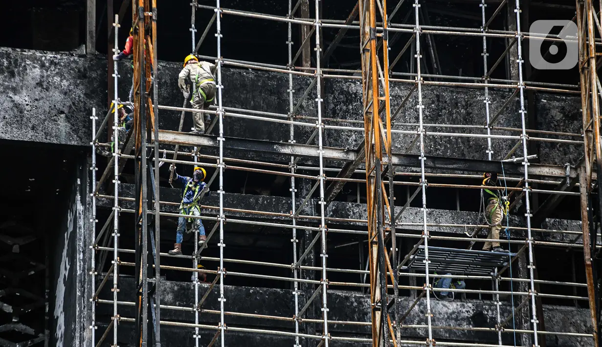 Pekerja memasang 'scaffolding' atau struktur besi untuk melakukan perbaikan Gedung Kejaksaan Agung, Jakarta, yang hangus terbakar, Rabu (7/10/2020).  Kebakaran pada 22 Agustus 2020 lalu mengakibatkan kerusakan berat pada seluruh bangunan Gedung Utama Kejaksaan Agung. (Liputan6.com/Faizal Fanani)