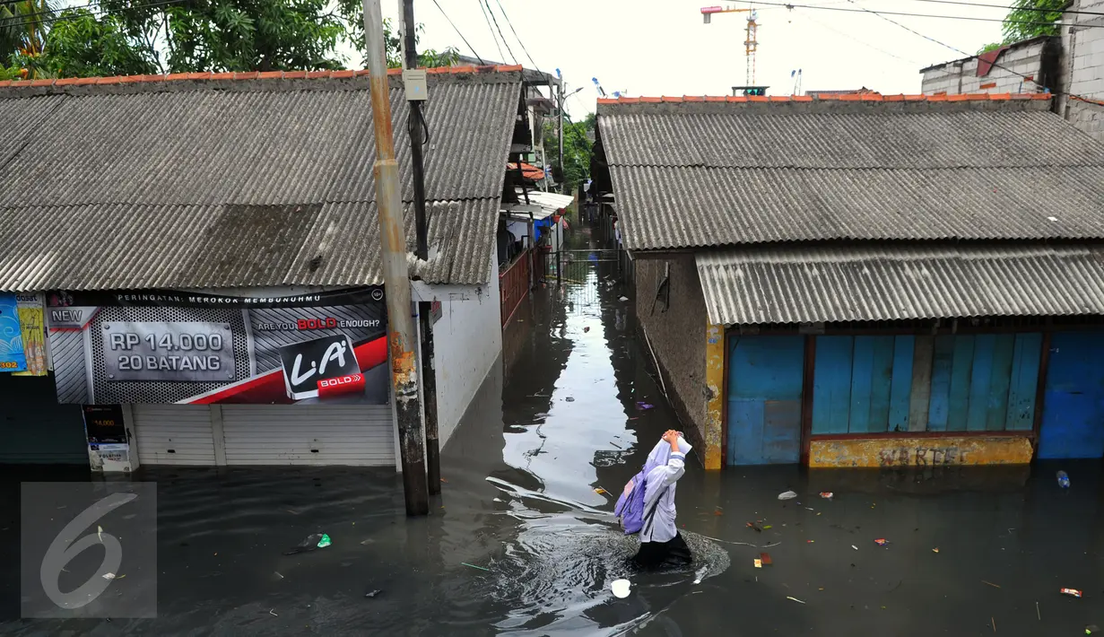 Warga melawati jalanan yang banjir di kawasan Jakarta Barat, Jumat (26/2). Banjir terjadi juga dikarenakan kali Daan Mogot yang  tak kunjung surut. (Liputan6.com/Faisal R Syam)