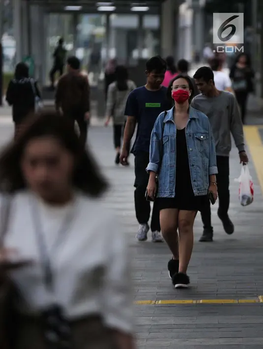Seorang wanita berjalan mengenakan masker pelindung untuk menghindari polusi udara buruk di Jakarta, Rabu (17/7/2019). Dinkes DKI menyarankan masyarakat untuk menggunakan masker saat beraktivitas untuk mencegah dampak polusi udara pada tubuh. (Liputan6.com/Faizal Fanani)