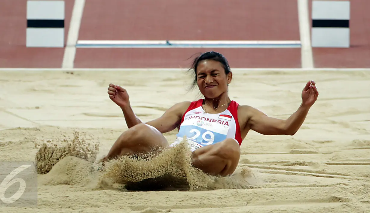 Atlet lompat jauh Indonesia, Maria Londa saat berhasil mendarat usai melakukan lompatan di nomor lompat jauh putri SEA Games 2015 di National Stadium, Singapura, Rabu (10/6/2015). Maria berhasil meraih emas. (Liputan6.com/Helmi Fithriansyah)